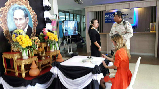 The woman in an orange dress who inscribed a book of condolences for the late King and was later subjected to an online witch-hunt. She also suffered from mental illness. (Picture: Manager Online)